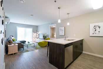 A modern kitchen with a large island and a dining area with a table and chairs.